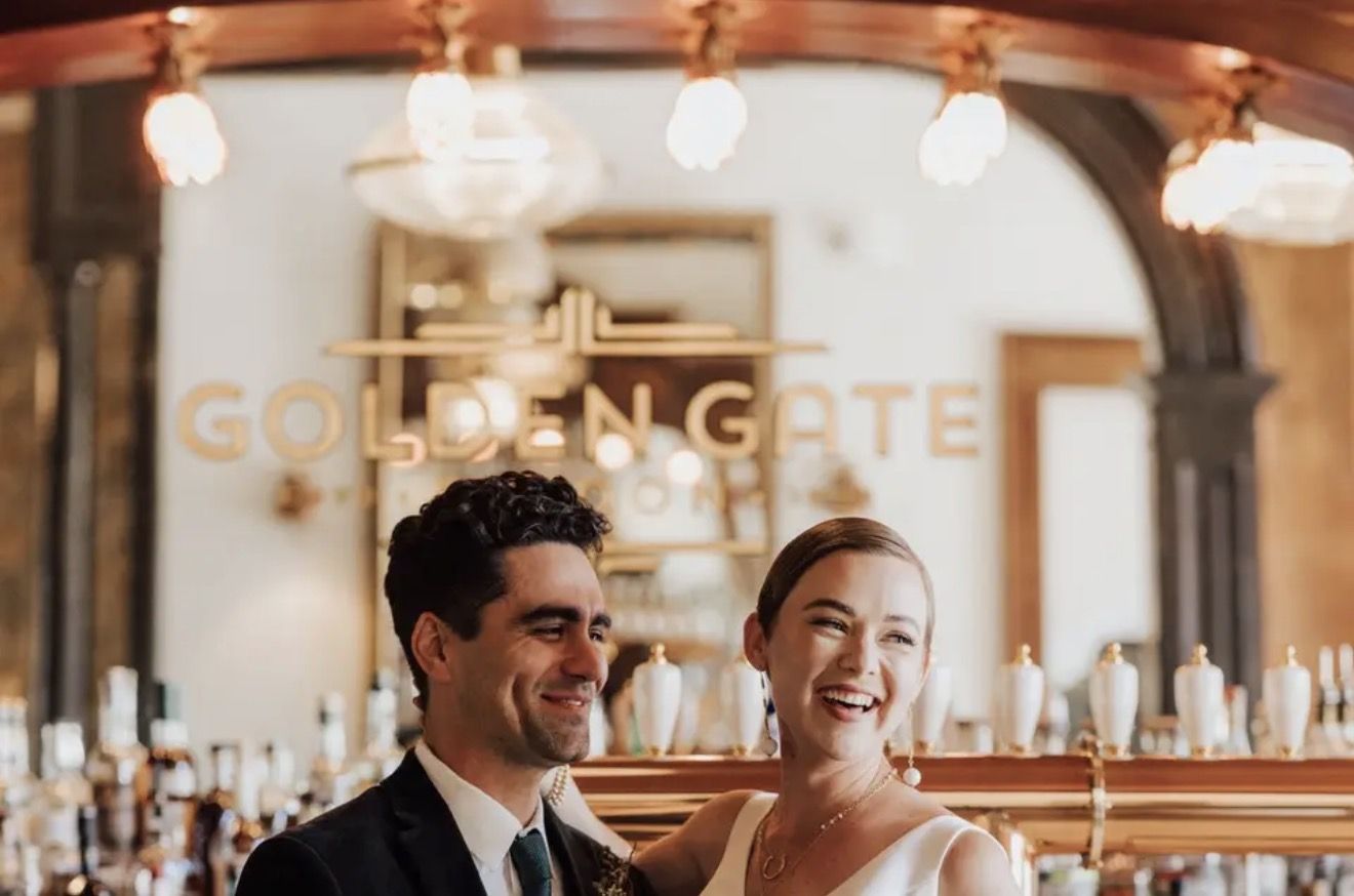 A couple laughing together at the bar of the Golden Gate Saloon